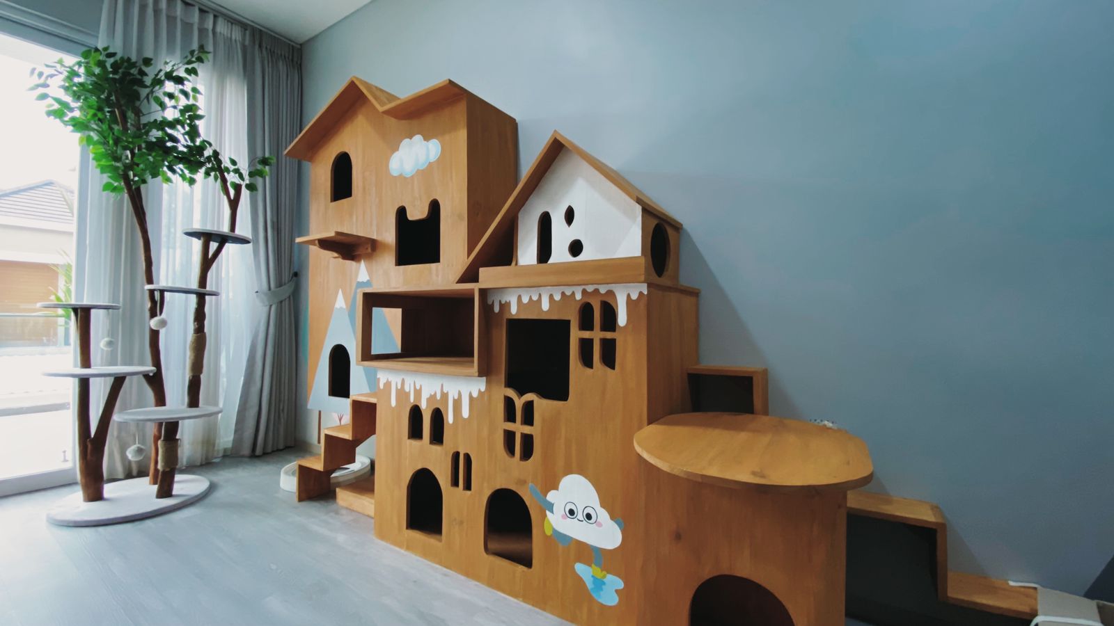 A complete custom PetCasa wooden playhouse and climbing tree inside a real home